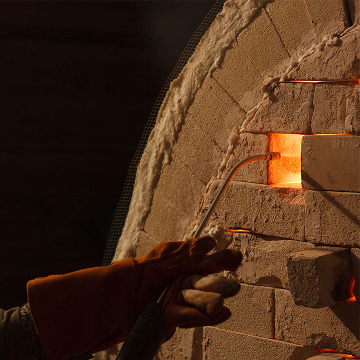 A nozzle to an opening of a soda firing kiln